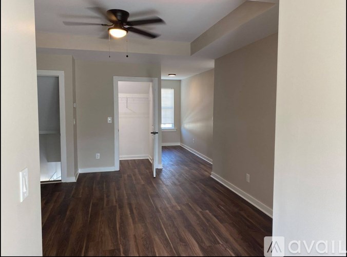 A room with a ceiling fan and wooden flooring.