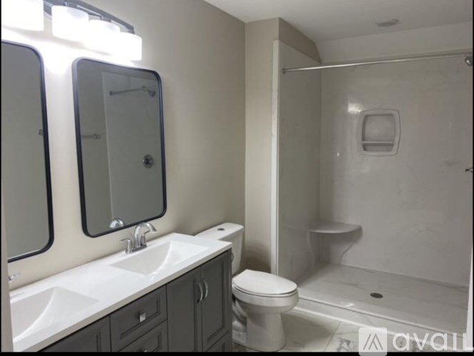 A bathroom with a toilet, sink, and mirror.