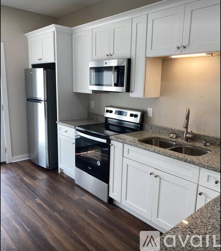 A kitchen with white cabinets and a granite countertop.