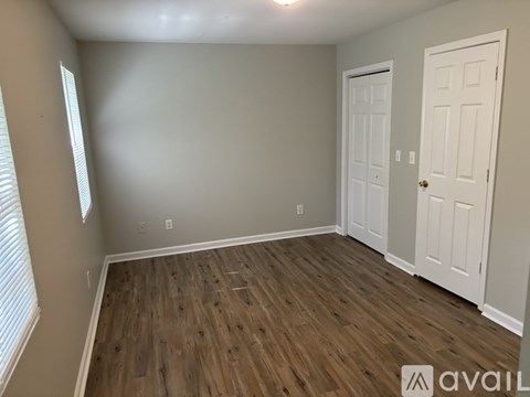 A room with wooden flooring and two white doors.