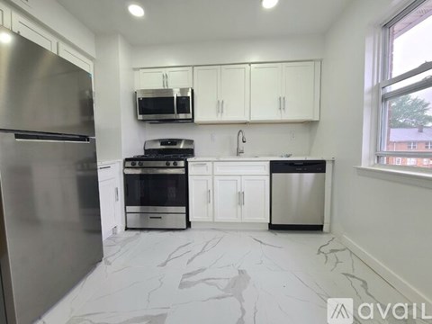A kitchen with a stainless steel refrigerator, microwave, oven, and cabinets.