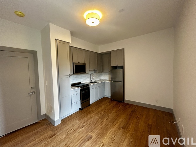 A kitchen with wooden floors and white appliances.