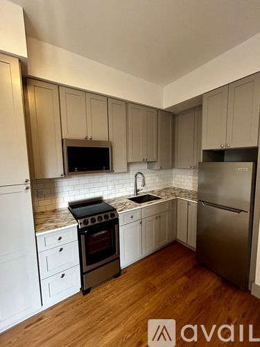 A kitchen with wooden cabinets and a stainless steel refrigerator.
