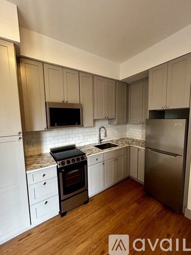 A kitchen with wooden cabinets and a stainless steel refrigerator.