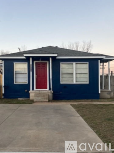A blue house with a red door and a red garage door.