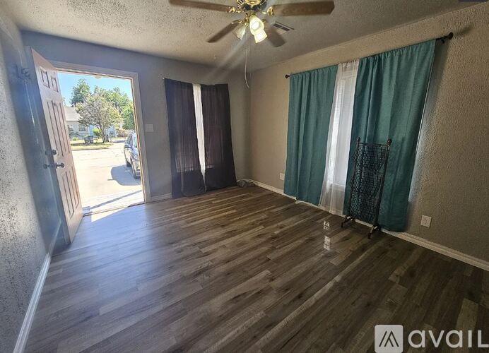 A room with wooden floors and a ceiling fan.