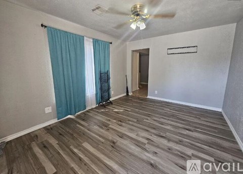 A room with wooden flooring and a ceiling fan.