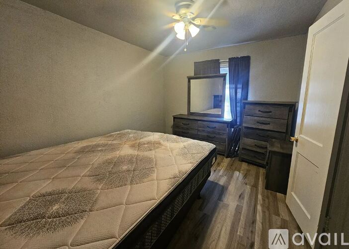 A bedroom with a bed, dresser, and mirror.