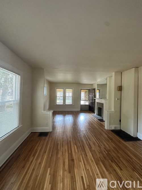A room with wooden floors and a fireplace.