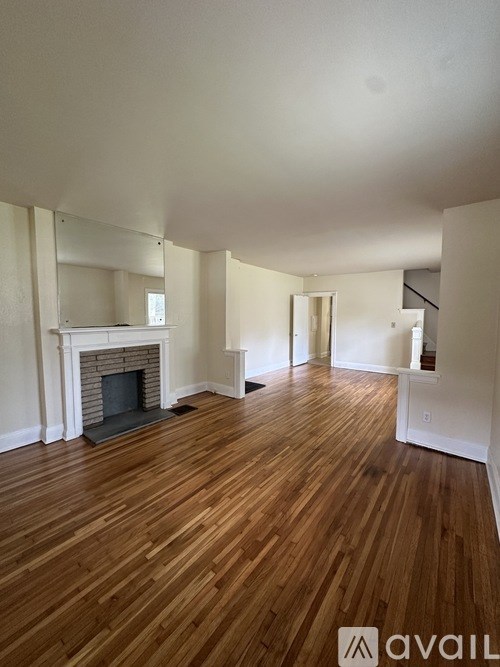 A room with wooden floors and a fireplace.