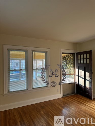 A room with wooden floors and a door leading to a balcony.
