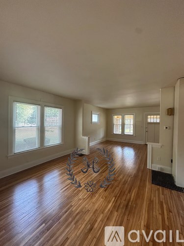 A room with wooden floors and a large window.