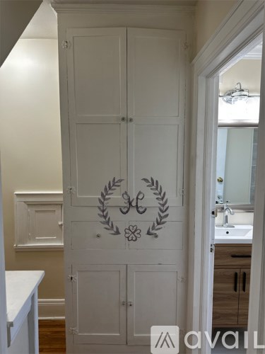 A white bathroom with a cabinet and a sink.