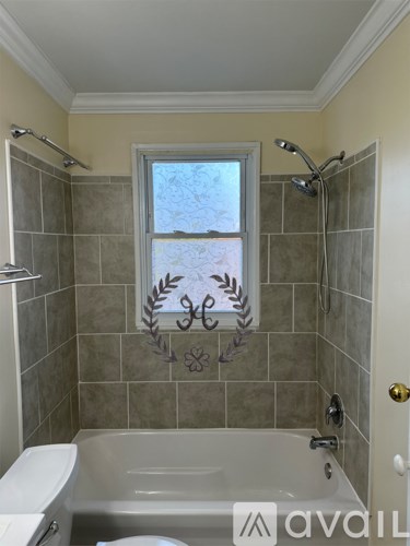 A bathroom with a tub, toilet, and shower.