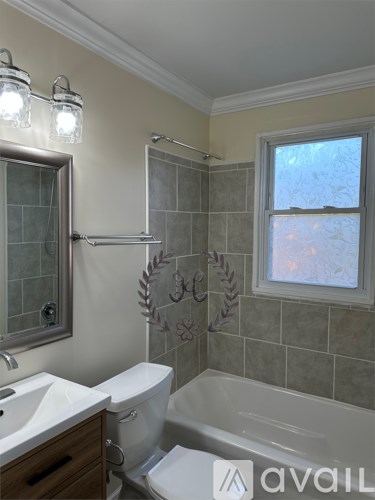 A bathroom with a toilet, sink, and bathtub.