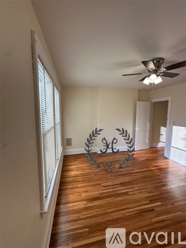 A room with wooden floors and a ceiling fan.