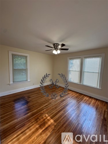 A room with wooden floors and a ceiling fan.