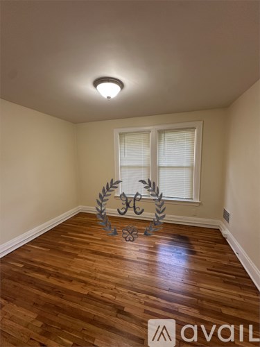 A room with wooden floors and a window with blinds.
