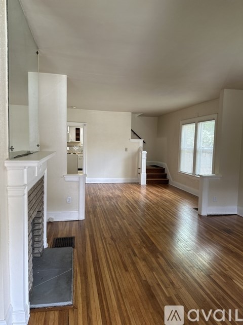 A living room with wood floors and a fireplace.