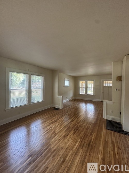 A room with wooden flooring and white walls.