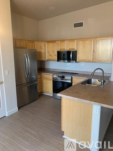 A kitchen with wooden cabinets and stainless steel appliances.