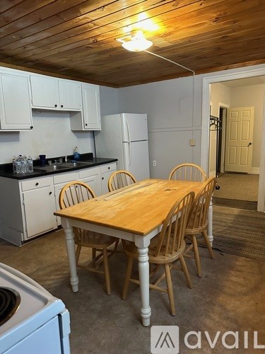 A kitchen with a table and chairs.