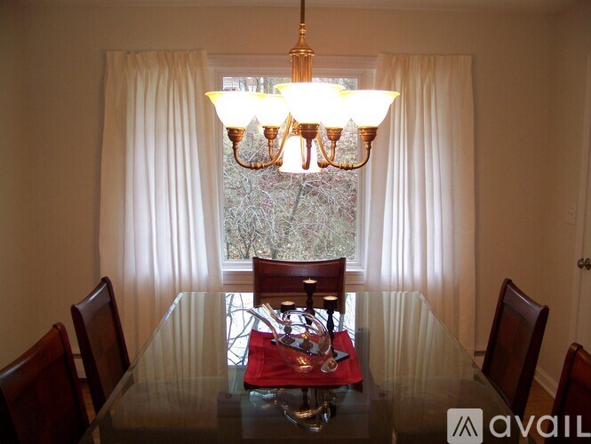 A dining room with a glass table and chairs.