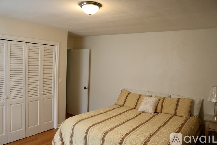 A bedroom with a bed, a lamp, and a wardrobe.