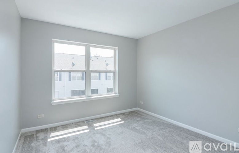 A room with a large window and a view of a building across the street.