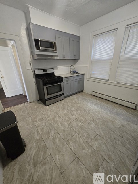 A kitchen with a black stove top oven and a microwave above it.