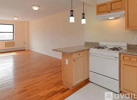 A kitchen with wooden cabinets and a white stove top oven.