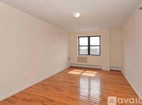 A room with wooden flooring and a window.