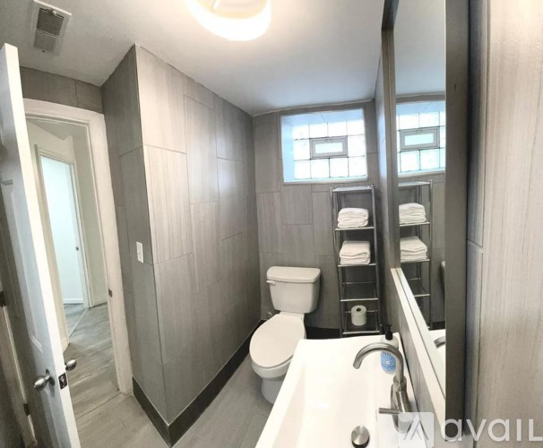 A bathroom with a toilet, sink, and mirror.