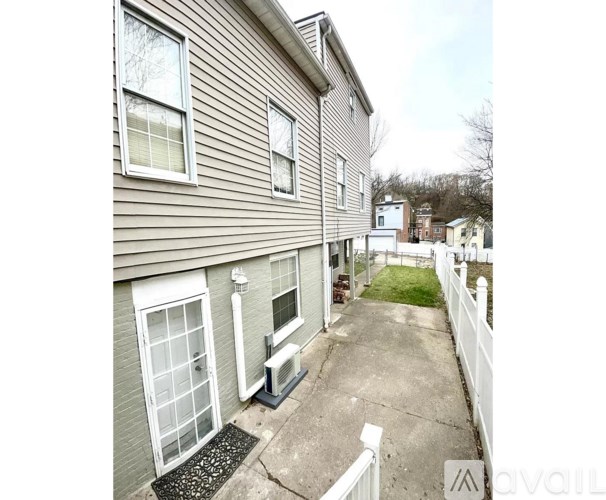 A house with a grey siding and white windows is for sale.
