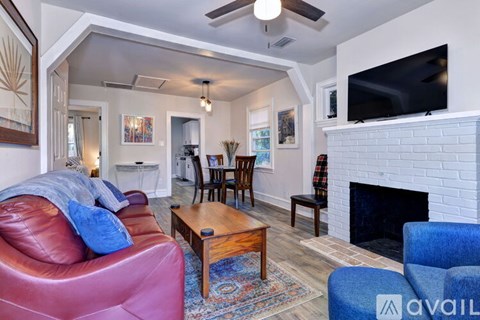 A living room with a red couch and a fireplace.