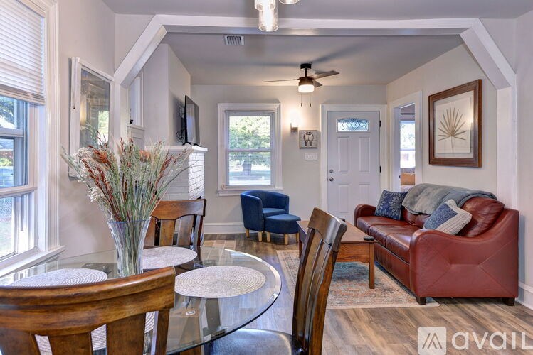 A living room with a red couch and a glass table.