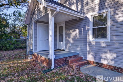 A house with a porch and a white door is available for rent.