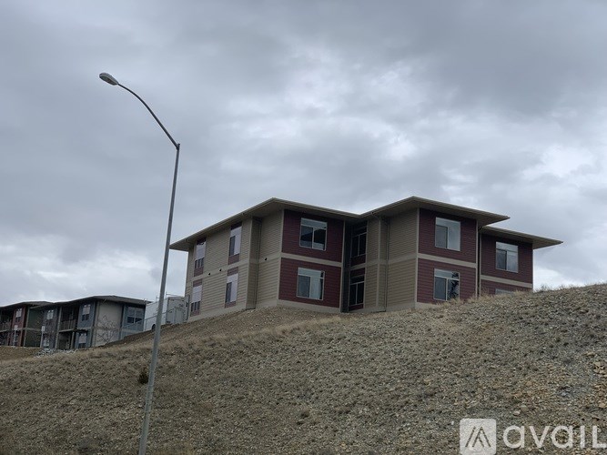 A building with a red roof is on a hill.