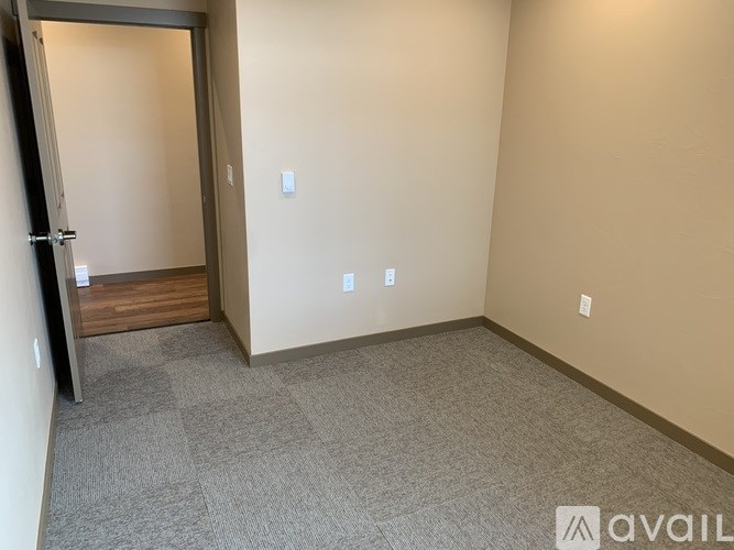A room with a carpeted floor and a door on the left.