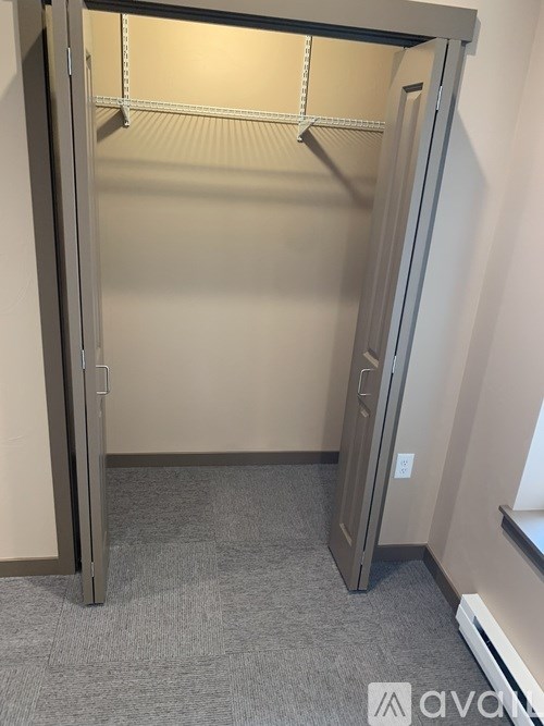 A large open closet with a grey carpeted floor.