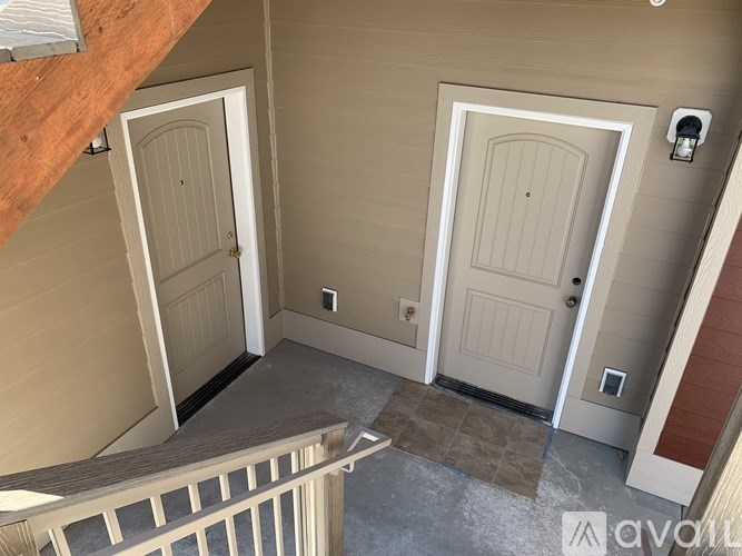 A hallway with two doors and a staircase.