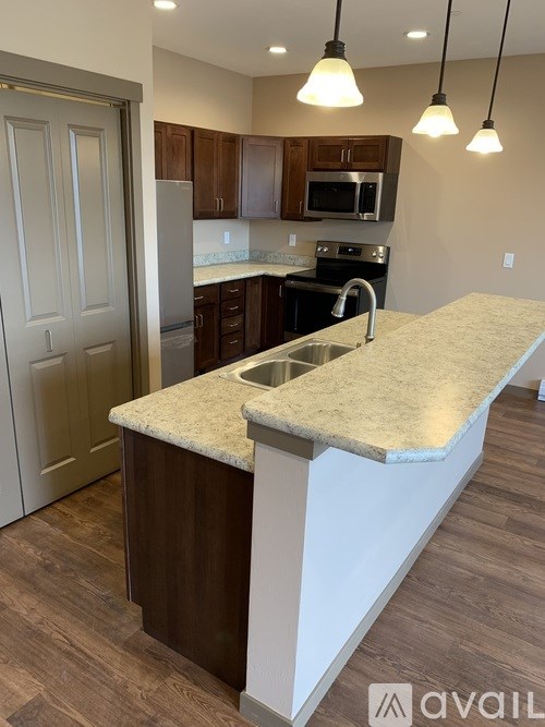 A kitchen with a white counter top and brown cabinets.