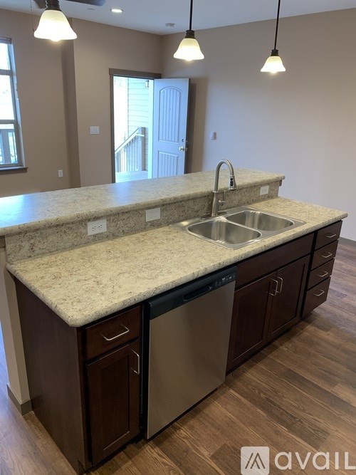 A kitchen with a granite countertop and wooden cabinets.