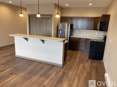 A kitchen with a white countertop and wooden flooring.