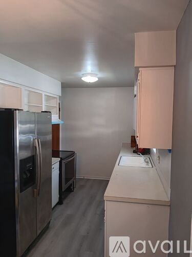 A kitchen with a refrigerator, oven, and sink.