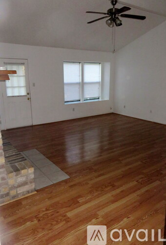 A room with wooden floors and a ceiling fan.