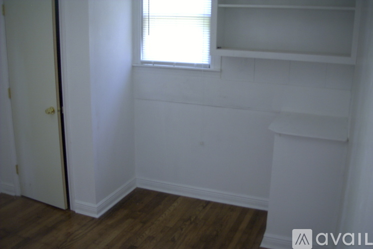 A room with a window and a shelf.