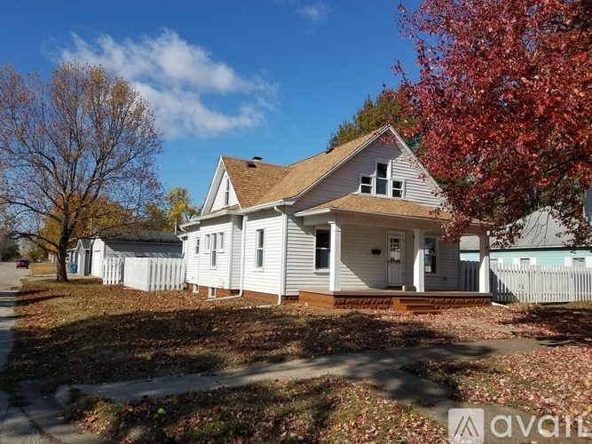 A house with a white picket fence in front of it.