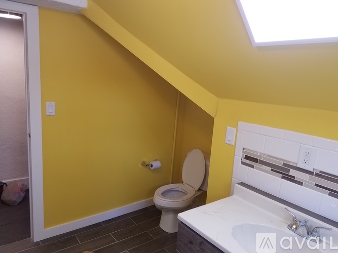 A bathroom with yellow walls and a white toilet.