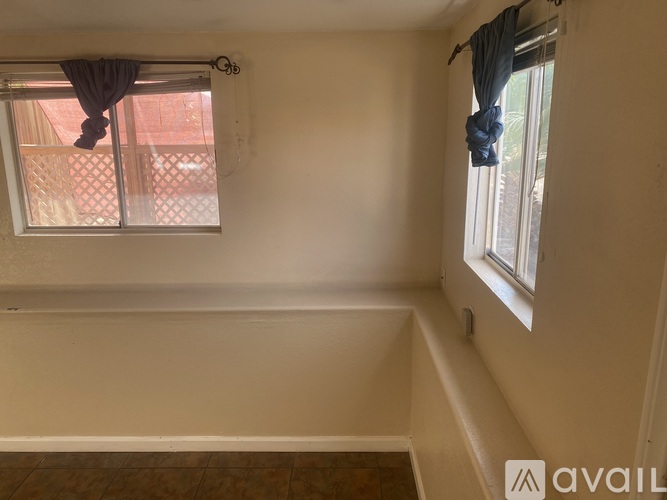 A room with a window and a view of a red building outside.